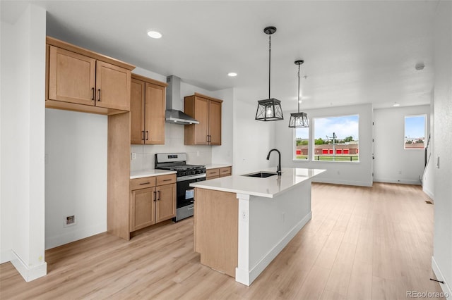 2736 W 68th Ave, Denver, CO 80221 - kitchen with stainless steel range with gas cooktop, wall chimney range hood, a sink, light wood-type flooring, and light countertops