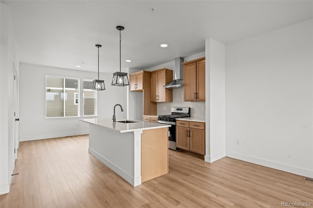 2736 W 68th Ave, Denver, CO 80221 - kitchen featuring stainless steel range with gas stovetop, a sink, wall chimney exhaust hood, light wood finished floors, and recessed lighting