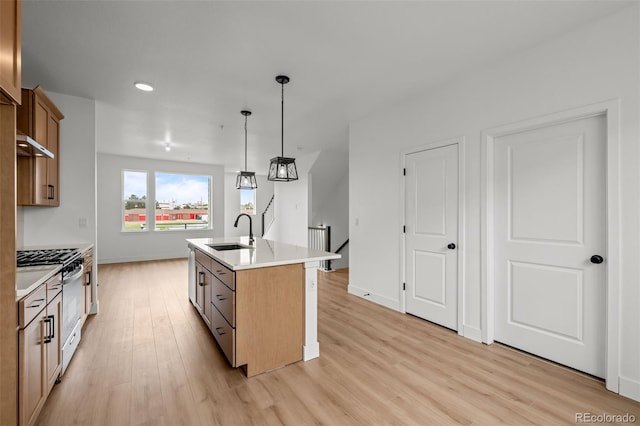 2736 W 68th Ave, Denver, CO 80221 - kitchen featuring gas range, a sink, light wood finished floors, light countertops, and hanging light fixtures
