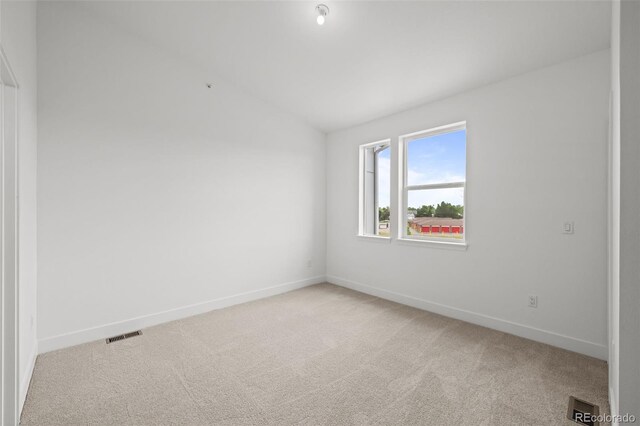 2736 W 68th Ave, Denver, CO 80221 - empty room featuring light carpet, lofted ceiling, and baseboards