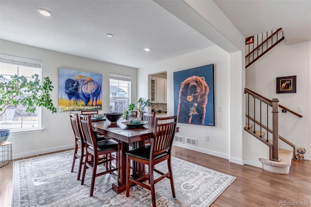 dining space with stairs, wood finished floors, baseboards, and recessed lighting
