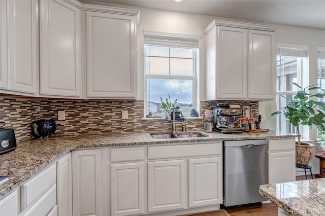 kitchen with dishwasher, a sink, and white cabinets