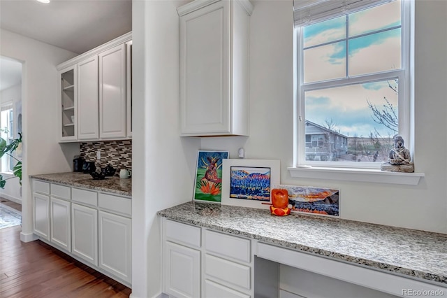 kitchen with healthy amount of natural light, backsplash, white cabinets, and dark wood-style floors