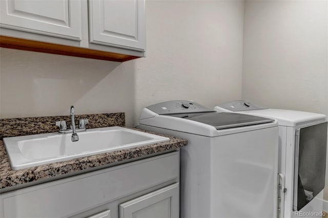 laundry area with separate washer and dryer and cabinet space