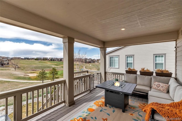 wooden deck with an outdoor living space with a fire pit