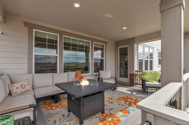 wooden terrace with an outdoor living space with a fire pit