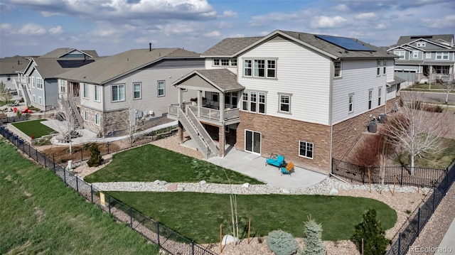 back of house with a residential view, a patio, stone siding, and a wooden deck