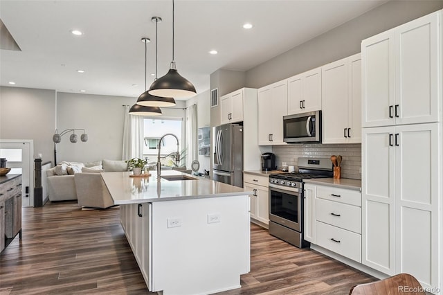 12320 W 51st Ave, Wheat Ridge, CO 80033 - kitchen with appliances with stainless steel finishes, open floor plan, an island with sink, backsplash, and recessed lighting