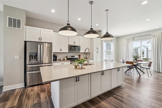 12320 W 51st Ave, Wheat Ridge, CO 80033 - kitchen featuring appliances with stainless steel finishes, backsplash, white cabinetry, dark wood-style flooring, and recessed lighting