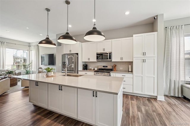 12320 W 51st Ave, Wheat Ridge, CO 80033 - kitchen featuring appliances with stainless steel finishes, open floor plan, light wood finished floors, and recessed lighting