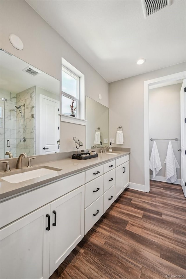 12320 W 51st Ave, Wheat Ridge, CO 80033 - full bathroom featuring a stall shower, double vanity, wood finished floors, and recessed lighting