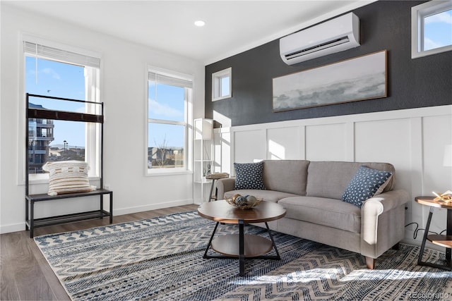 living room with a wealth of natural light, dark hardwood / wood-style flooring, and a wall unit AC