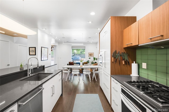1718 W 33rd Ave, Denver, CO 80211 - kitchen featuring dishwasher, a sink, dark countertops, dark wood-style flooring, and recessed lighting