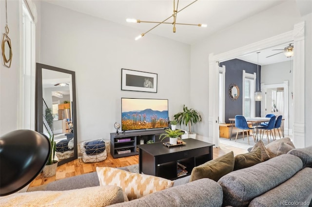 living room featuring a chandelier, wood finished floors, and ceiling fan