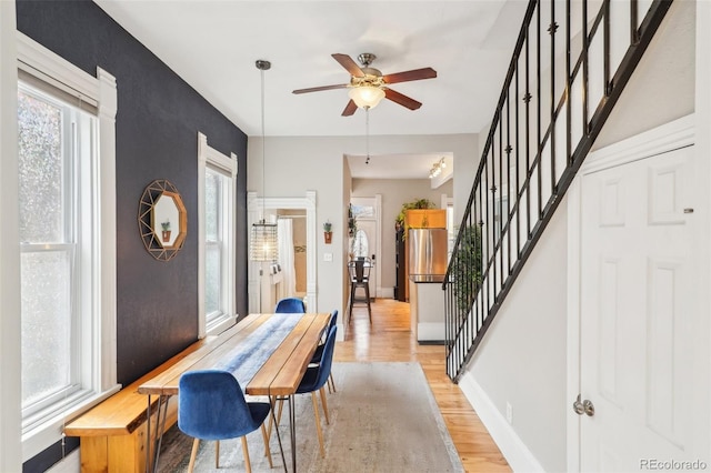 entryway featuring light wood finished floors, stairway, plenty of natural light, and ceiling fan