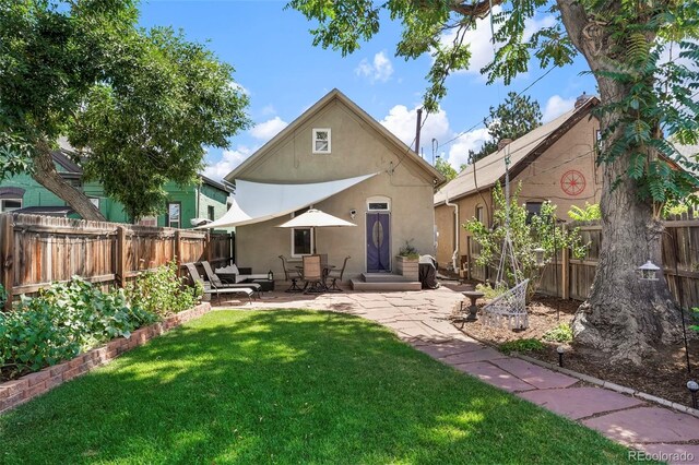 back of property with stucco siding and a patio