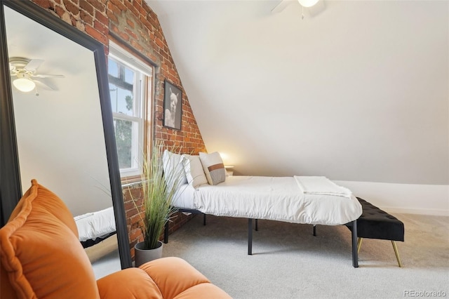 bedroom with vaulted ceiling, carpet, ceiling fan, and brick wall
