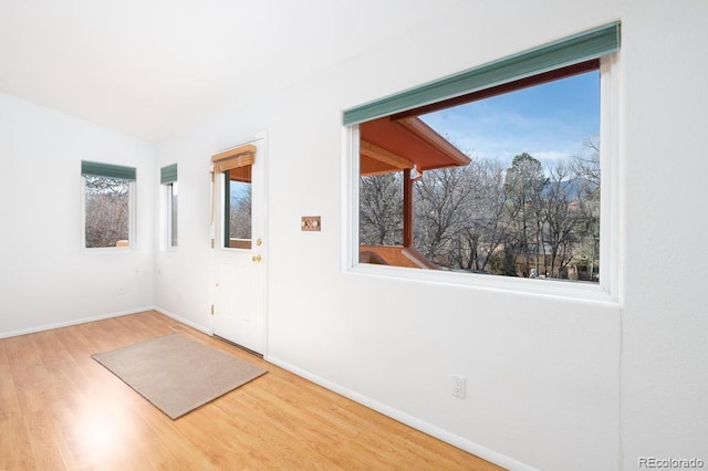 spare room featuring hardwood / wood-style flooring and vaulted ceiling