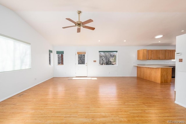 unfurnished living room featuring ceiling fan, light wood-type flooring, and vaulted ceiling