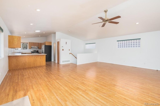 unfurnished living room featuring ceiling fan, light wood-type flooring, and lofted ceiling