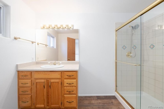 bathroom featuring a shower with door, vanity, and wood-type flooring