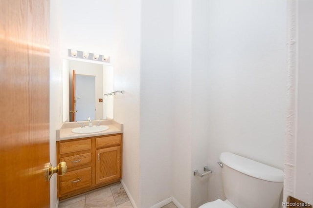 bathroom with toilet, vanity, and tile patterned floors