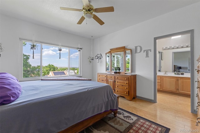 12277 W Chenango Dr, Morrison, CO 80465 - bedroom with light wood finished floors, multiple windows, connected bathroom, and ceiling fan