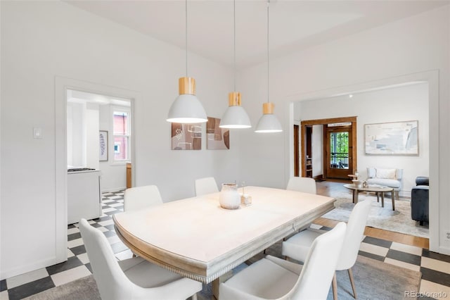 dining area with tile patterned floors and a towering ceiling