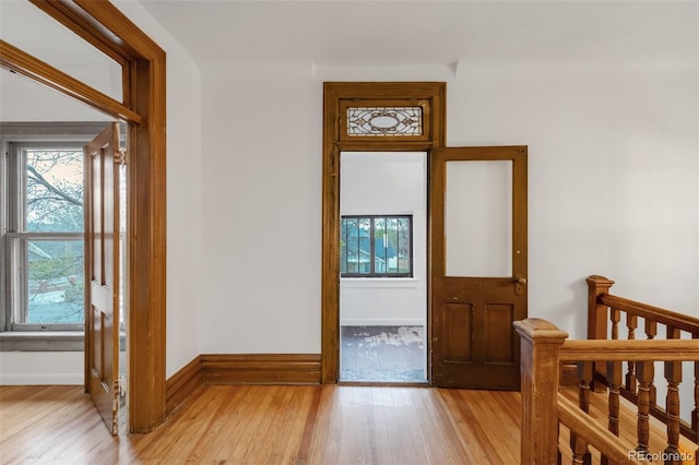 doorway to outside featuring baseboards and light wood-style flooring