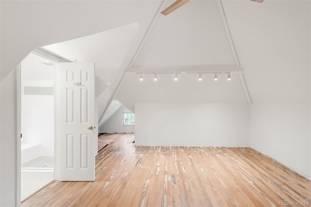 additional living space with wood-type flooring and lofted ceiling
