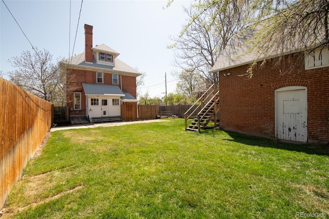 view of yard featuring a wooden deck, a fenced backyard, and stairs