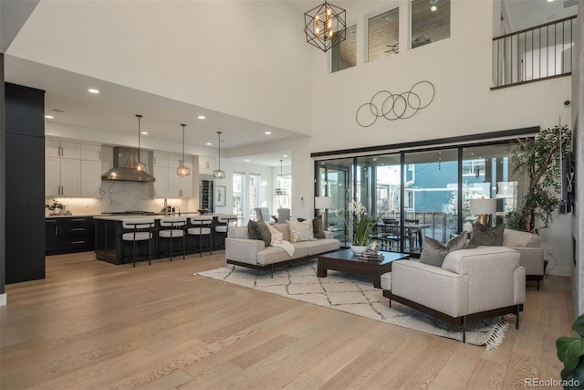 living room with light wood-type flooring, a notable chandelier, and a wealth of natural light