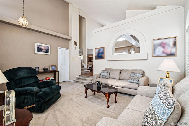 living room featuring a towering ceiling and carpet floors