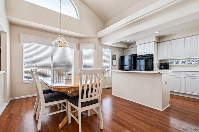 dining space featuring dark wood-type flooring and vaulted ceiling