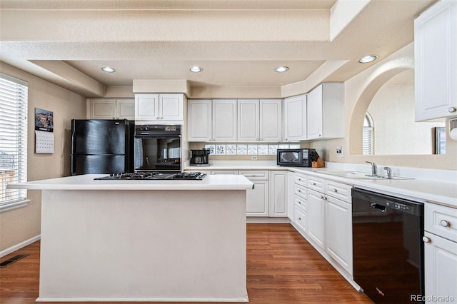 kitchen with white cabinetry, sink, black appliances, and a center island