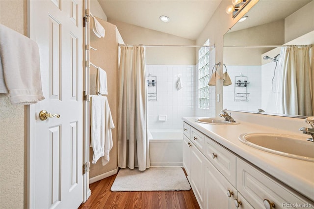 bathroom featuring shower / bath combination with curtain, lofted ceiling, wood-type flooring, and vanity