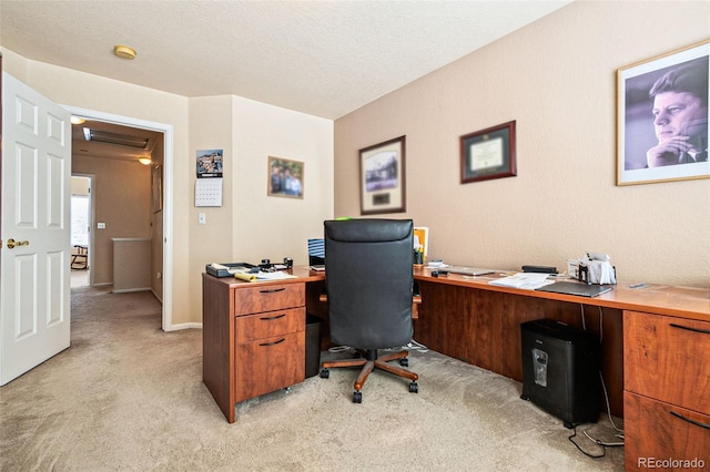 carpeted office space featuring a textured ceiling