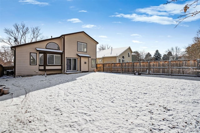 view of snow covered rear of property