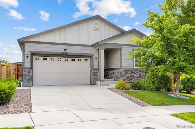 9628 Albion Ln, Thornton, CO 80229 - view of front of home with stone siding, board and batten siding, a garage, and concrete driveway