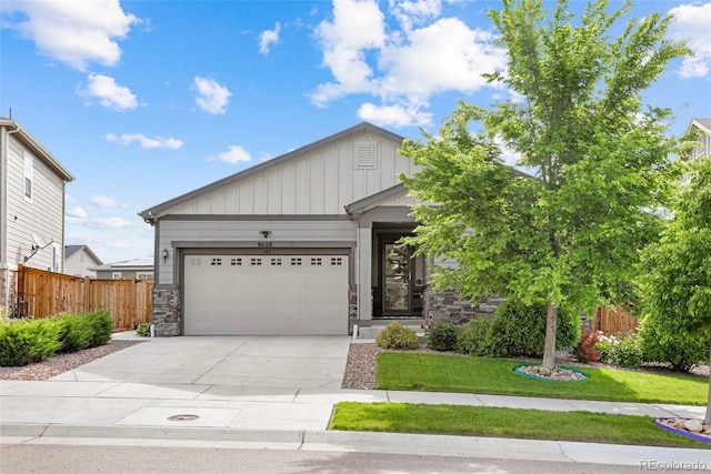 9628 Albion Ln, Thornton, CO 80229 - view of front facade featuring a garage, concrete driveway, board and batten siding, and stone siding