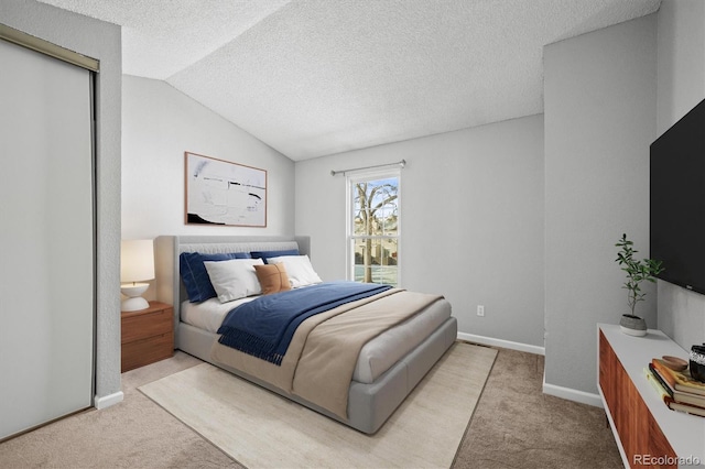 carpeted bedroom with lofted ceiling and a textured ceiling