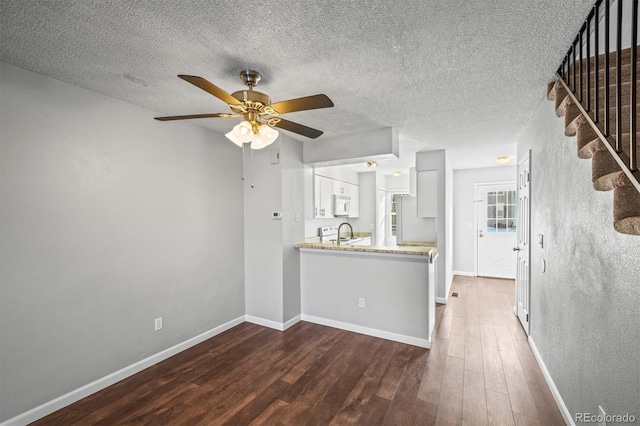 kitchen featuring sink, white appliances, dark wood-type flooring, ceiling fan, and white cabinets