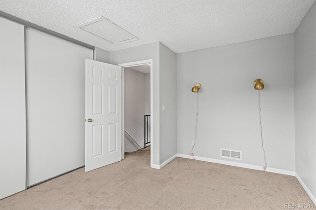 carpeted empty room featuring a textured ceiling