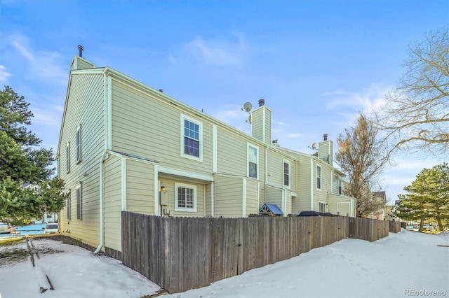 view of snow covered rear of property