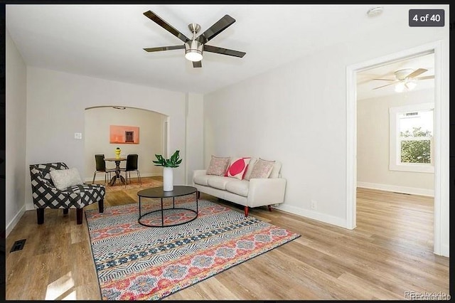 living room featuring light hardwood / wood-style flooring and ceiling fan