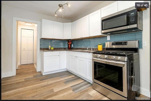 kitchen featuring white cabinets, appliances with stainless steel finishes, and light hardwood / wood-style floors