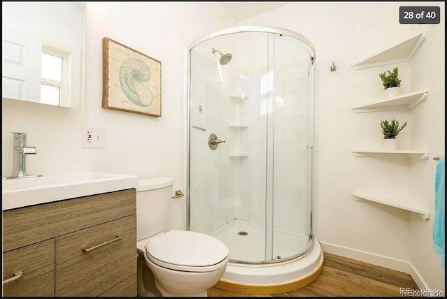 bathroom featuring vanity, toilet, wood-type flooring, and walk in shower