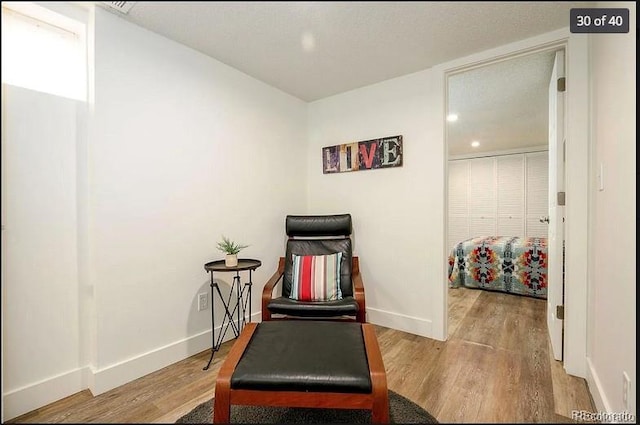 sitting room with hardwood / wood-style flooring