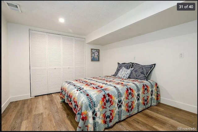 bedroom with hardwood / wood-style flooring and a closet