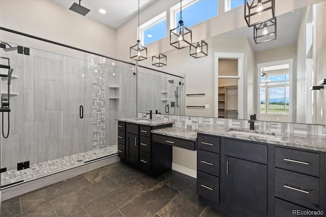 bathroom featuring tile patterned floors, a shower with door, and vanity